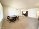 Spacious living area with neutral carpeting, arched doorways, and vintage furniture, ideal for Gathering gatherings at 8217 E Medina Ave, Mesa, AZ 85209