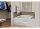 Bathroom soaking tub featuring a window with blinds and a nearby walk-in closet at 9009 S 57Th Dr, Laveen, AZ 85339