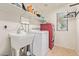 Well-equipped laundry room with modern washer, dryer, and ample shelving for storage at 9009 S 57Th Dr, Laveen, AZ 85339