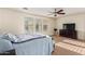 Bright main bedroom featuring a ceiling fan, carpet floors, and a dresser beneath the TV at 9009 S 57Th Dr, Laveen, AZ 85339