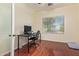 Home office with modern desk setup and hardwood flooring provides a productive workspace at 9009 S 57Th Dr, Laveen, AZ 85339