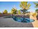 Desert landscape surrounds this inviting pool area with mature trees and decorative rock at 9009 S 57Th Dr, Laveen, AZ 85339