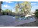 Inviting backyard pool with surrounding stone patio and mature desert trees at 9009 S 57Th Dr, Laveen, AZ 85339