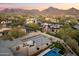 An aerial shot of the property featuring a pool, patios, multiple firepits, mountain views and more at 9735 E Kemper Way, Scottsdale, AZ 85255
