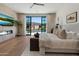 Bright bedroom featuring a large window with pool view, hardwood floors, and fireplace with television at 9735 E Kemper Way, Scottsdale, AZ 85255
