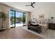 Bright bedroom featuring a large window with pool view, hardwood floors, and neutral, modern decor at 9735 E Kemper Way, Scottsdale, AZ 85255