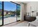 Bright bedroom featuring large glass doors with pool view and contemporary decor at 9735 E Kemper Way, Scottsdale, AZ 85255