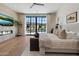 Bright bedroom featuring a large window with pool view, hardwood floors, and fireplace with television at 9735 E Kemper Way, Scottsdale, AZ 85255