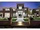 Elegant home featuring a beautifully landscaped front yard, a symmetrical facade, and inviting entryway with uplighting at 9735 E Kemper Way, Scottsdale, AZ 85255