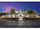 Striking modern home exterior featuring a grand entrance, mature trees, and manicured landscaping at twilight at 9735 E Kemper Way, Scottsdale, AZ 85255