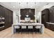 Modern kitchen with a large marble island, dark wood cabinets, and stylish pendant lighting at 9735 E Kemper Way, Scottsdale, AZ 85255