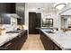 Modern kitchen featuring an island with marble countertops, dark wood cabinetry, and stainless steel appliances at 9735 E Kemper Way, Scottsdale, AZ 85255