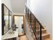 Modern staircase with wood treads, black metal railing, and bright wall sconces at 9735 E Kemper Way, Scottsdale, AZ 85255