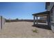 Expansive gravel backyard with covered patio, ideal for outdoor living and relaxation at 18207 W Daley Ln, Surprise, AZ 85387