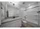 Modern bathroom featuring granite counters, white cabinetry, and tub with dark fixtures at 18207 W Daley Ln, Surprise, AZ 85387
