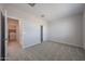 Bedroom with plush carpet, closet with sliding doors, and nearby laundry room at 18207 W Daley Ln, Surprise, AZ 85387