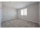 Bright bedroom features neutral carpet, paint, and window with blinds at 18207 W Daley Ln, Surprise, AZ 85387