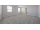Spacious bonus room with two windows and neutral carpet and paint at 18207 W Daley Ln, Surprise, AZ 85387