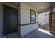 Inviting front entry featuring a modern black door and stylish stone-accented columns at 18207 W Daley Ln, Surprise, AZ 85387
