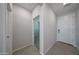 Neutral-toned hallway with tile floors, showcasing doorways leading to bedrooms with neutral carpet at 18207 W Daley Ln, Surprise, AZ 85387