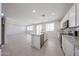 Modern kitchen featuring an island, stainless steel appliances and a living area at 18207 W Daley Ln, Surprise, AZ 85387