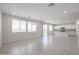 Spacious living room with large windows, tile floors, and an open view of the modern kitchen at 18207 W Daley Ln, Surprise, AZ 85387