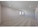 Large loft area featuring neutral carpet, white railings, and natural light at 18207 W Daley Ln, Surprise, AZ 85387
