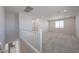 Upstairs loft area featuring neutral carpet, white railings, and natural light from the window at 18207 W Daley Ln, Surprise, AZ 85387