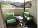 Relaxing balcony area with comfortable chairs, a table, and an umbrella providing shade at 1941 S Pierpont Dr # 1025, Mesa, AZ 85206