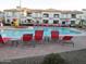 Sparkling community pool with red lounge chairs and umbrellas, surrounded by well-maintained apartment buildings at 1941 S Pierpont Dr # 1025, Mesa, AZ 85206