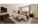 Serene bedroom with an upholstered bed, neutral tones, and large windows offering natural light at 3747 E Harmony Ave, Mesa, AZ 85206