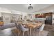 Spacious dining room features a modern light fixture, dining table and seating for a large gathering at 3747 E Harmony Ave, Mesa, AZ 85206