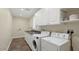 Functional laundry room with white cabinets, a utility sink, and modern washer and dryer units at 3747 E Harmony Ave, Mesa, AZ 85206