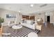 Bright living room with white furniture, modern light fixture, and an open view into the kitchen at 3747 E Harmony Ave, Mesa, AZ 85206