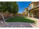 Well-manicured backyard with artificial grass, string lights, and brick patio, perfect for entertaining at 4059 E Mesquite St, Gilbert, AZ 85296