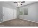 Neutral bedroom with a ceiling fan, carpet flooring, window, and closet with sliding doors at 4059 E Mesquite St, Gilbert, AZ 85296