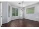 Bright dining area with hardwood flooring, large windows, and a contemporary light fixture at 4059 E Mesquite St, Gilbert, AZ 85296