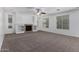 Spacious living room featuring a fireplace, shelving, neutral carpet, and bright natural light at 4059 E Mesquite St, Gilbert, AZ 85296