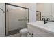This bathroom features a tiled shower with glass door, white vanity and modern black hardware at 1246 E Penedes Dr, Gilbert, AZ 85298