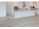 Bright kitchen with white cabinetry, a large island, and wood-look tile flooring, creating a modern space at 1246 E Penedes Dr, Gilbert, AZ 85298