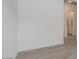 Living room featuring wood-look tile flooring and white walls leading to a hall at 1246 E Penedes Dr, Gilbert, AZ 85298