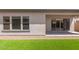Backyard featuring artificial grass, desert landscaping, a sliding glass door, and stucco wall at 19323 W San Juan Ave, Litchfield Park, AZ 85340