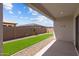 Covered patio with artificial grass, gravel, block wall, and desert landscaping in the backyard at 19323 W San Juan Ave, Litchfield Park, AZ 85340