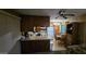 This kitchenette includes appliances, dark wood cabinets, breakfast bar, and dining table at 25 S 102Nd St # 79, Mesa, AZ 85208