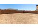 Spacious dirt backyard enclosed by a tall block wall, offering privacy and potential for landscaping at 5011 W Hardtack Trl, Laveen, AZ 85339