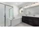 Bright bathroom featuring double sinks, a large soaking tub, and a glass-enclosed shower at 5011 W Hardtack Trl, Laveen, AZ 85339