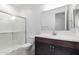 Bright bathroom featuring a sleek vanity, modern fixtures, and a glass-enclosed shower with tiled walls at 5011 W Hardtack Trl, Laveen, AZ 85339