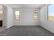Carpeted bedroom with two windows providing natural light and an attached bathroom vanity in view at 5011 W Hardtack Trl, Laveen, AZ 85339
