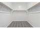 Walk-in closet with ample storage space, featuring wooden rods and neutral-toned carpeting at 5011 W Hardtack Trl, Laveen, AZ 85339