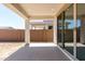 Covered patio with a concrete floor, sliding glass door, and view of the block wall and neighboring houses at 5011 W Hardtack Trl, Laveen, AZ 85339